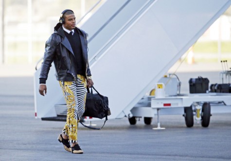FILE - In this Jan. 31, 2016 file photo, Carolina Panthers quarterback Cam Newton gets off the plane at the Mineta San Jose International Airport in San Jose, Calif.  The Panthers play the Denver Broncos on Sunday, Feb. 7, 2015, in Super Bowl 50. Newton was snapped Sunday in the zebra stripe, gold swirl rocker pants immediately setting social media and TV talking heads into a frenzy. (AP Photo/Charlie Riedel, File)
