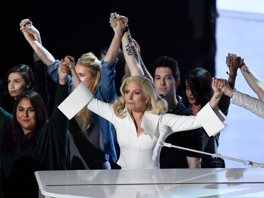 Lady Gaga holds hands with her fellow survivor. 