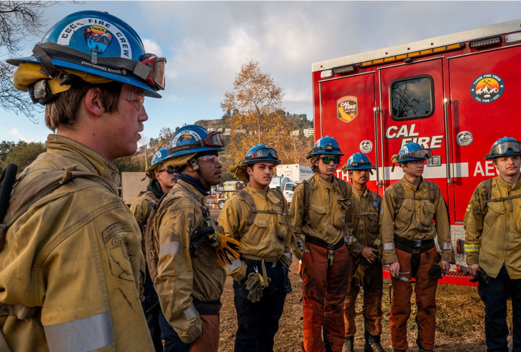 A California Conservation Corps fire crew gathers during a meeting before beginning their shift at the Rose Bowl Stadium on Friday, in Pasadena, California. 